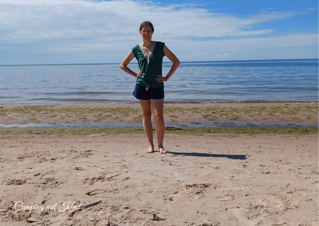 Eine Frau steht am Strand vor dem Meer